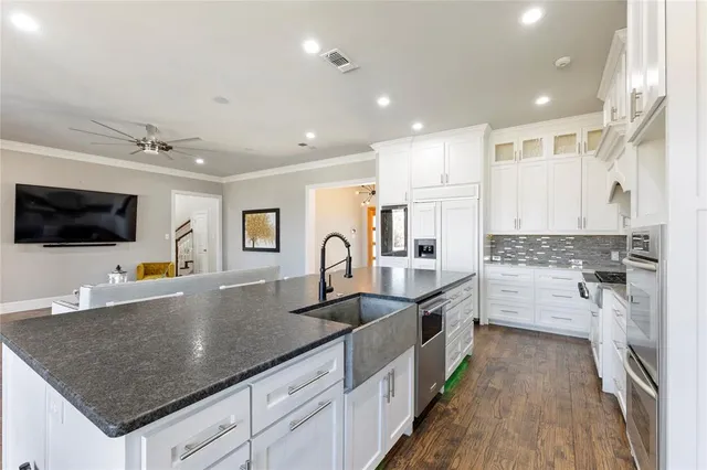 a kitchen with stainless steel appliances granite countertop a sink and a stove