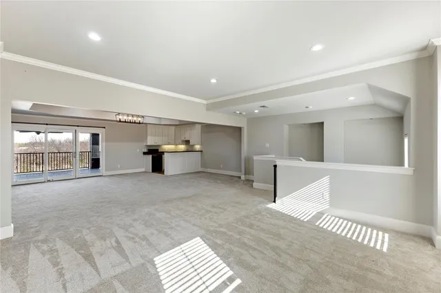 a large kitchen with kitchen island a large counter top a sink cabinets and stainless steel appliances