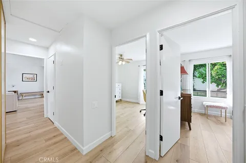 a view of a hallway with bathroom and wooden floor