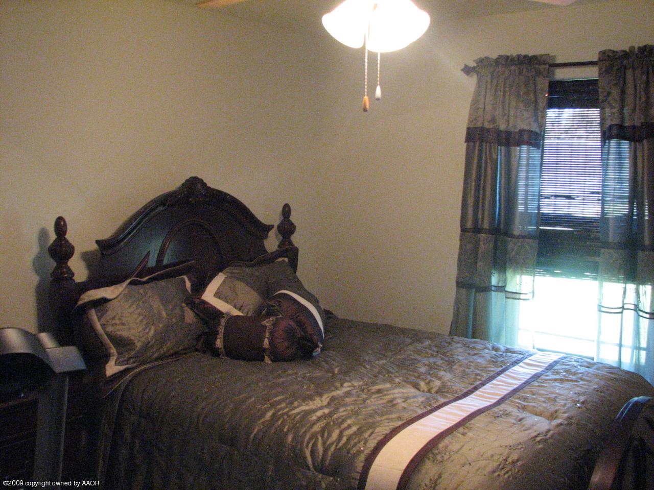 6602 Slater Circle Amarillo, TX 79110 - Photo 14 of 25 a bedroom with a bed and a chandelier