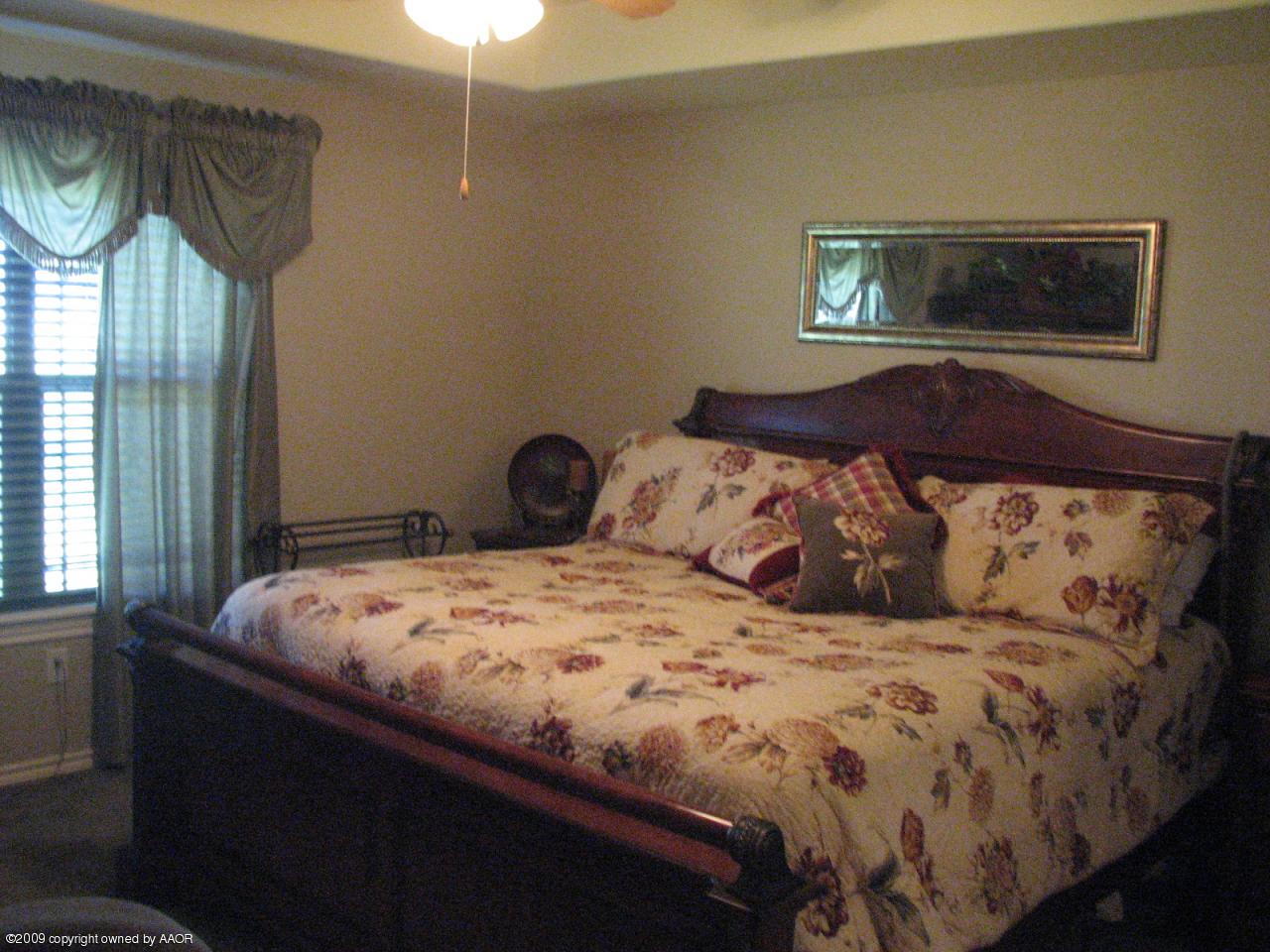 6602 Slater Circle Amarillo, TX 79110 - Photo 6 of 25 a bedroom with a bed a mirror and a window