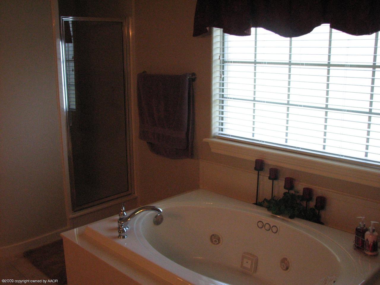 6602 Slater Circle Amarillo, TX 79110 - Photo 9 of 25 a bathroom with a tub and a sink