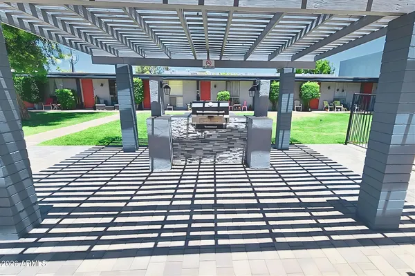 a patio with a table and chairs under an umbrella