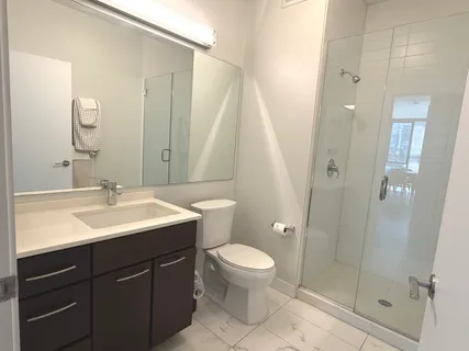 a bathroom with a sink a toilet and shower