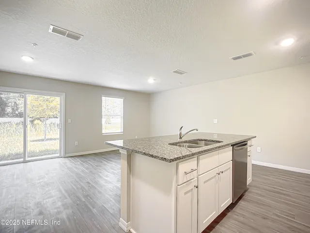 a bathroom with a granite countertop sink and a window