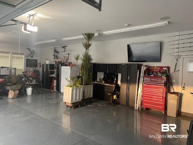 32937 River Road Orange Beach, AL 36561 - Photo 42 of 42 Garage featuring black refrigerator, white refrigerator, and a garage door opener