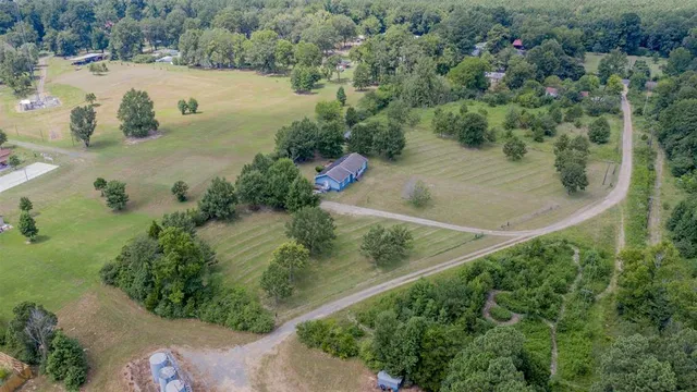 an aerial view of residential houses with outdoor space and trees all around