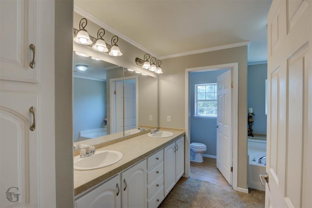 4807 Greenwood Heights Road Greenwood, LA 71033 - Photo 5 of 21 a spacious bathroom with a granite countertop sink a mirror and a toilet