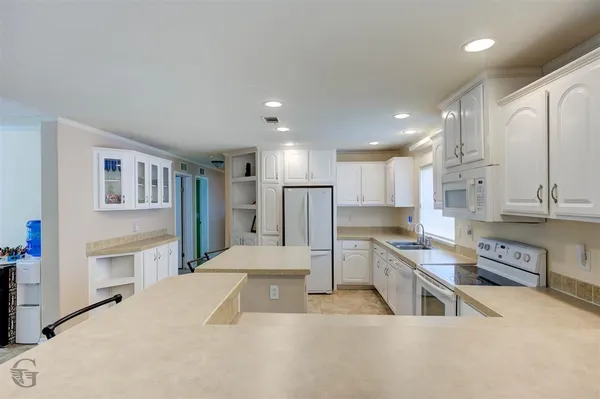 a large kitchen with stainless steel appliances kitchen island granite countertop a sink and cabinets