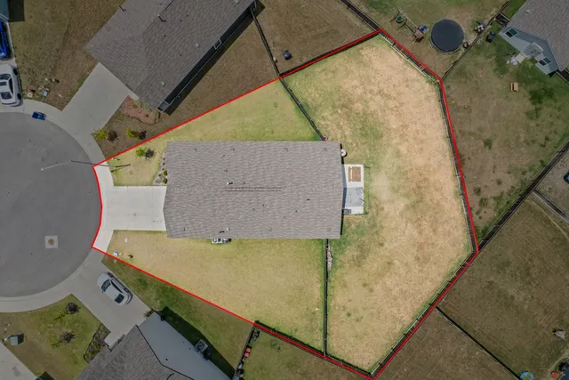 an aerial view of a house with a yard