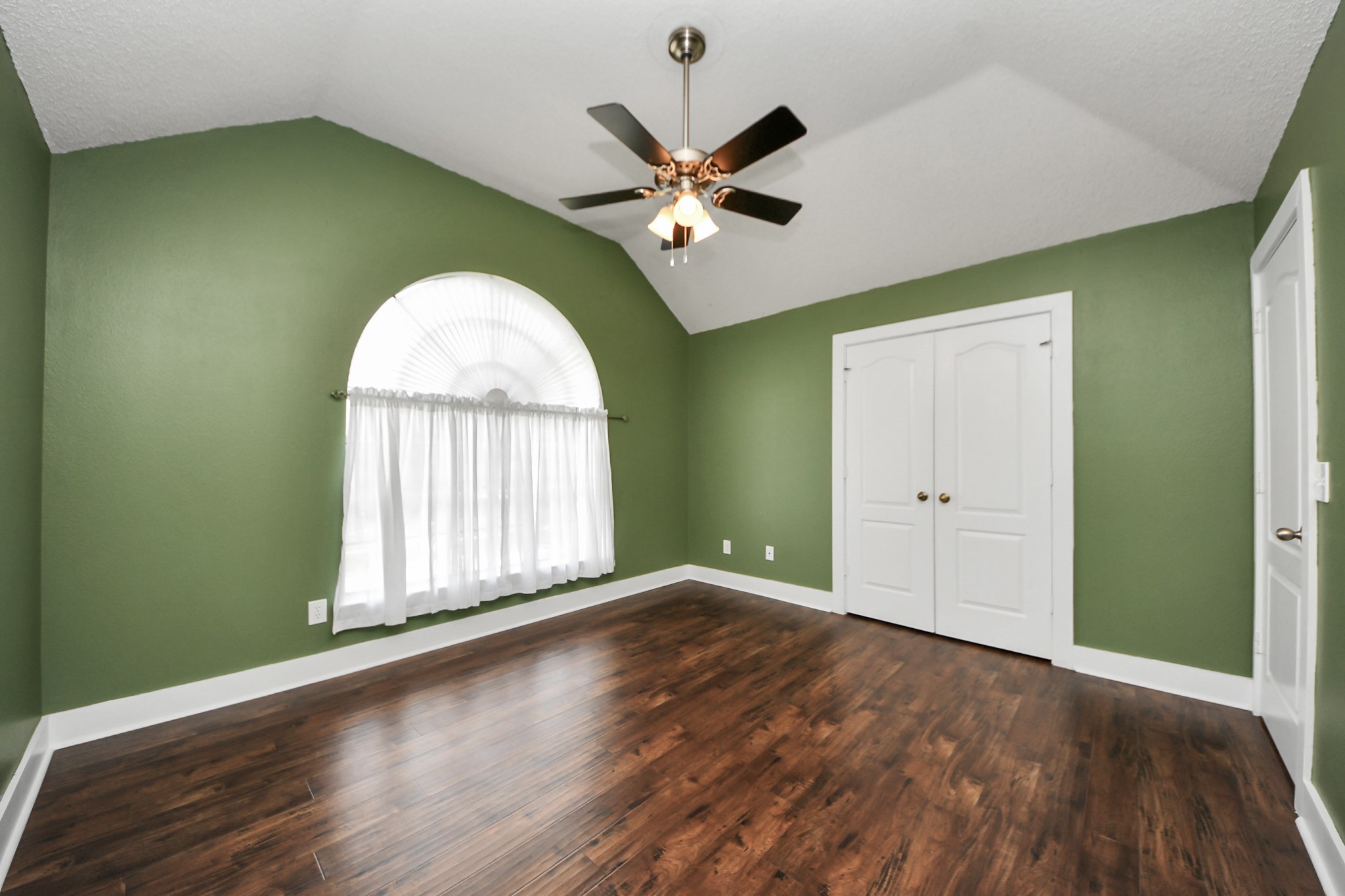 3107 Dulaney Road Houston, TX 77084 - Photo 35 of 50 an empty room with wooden floor fan and windows