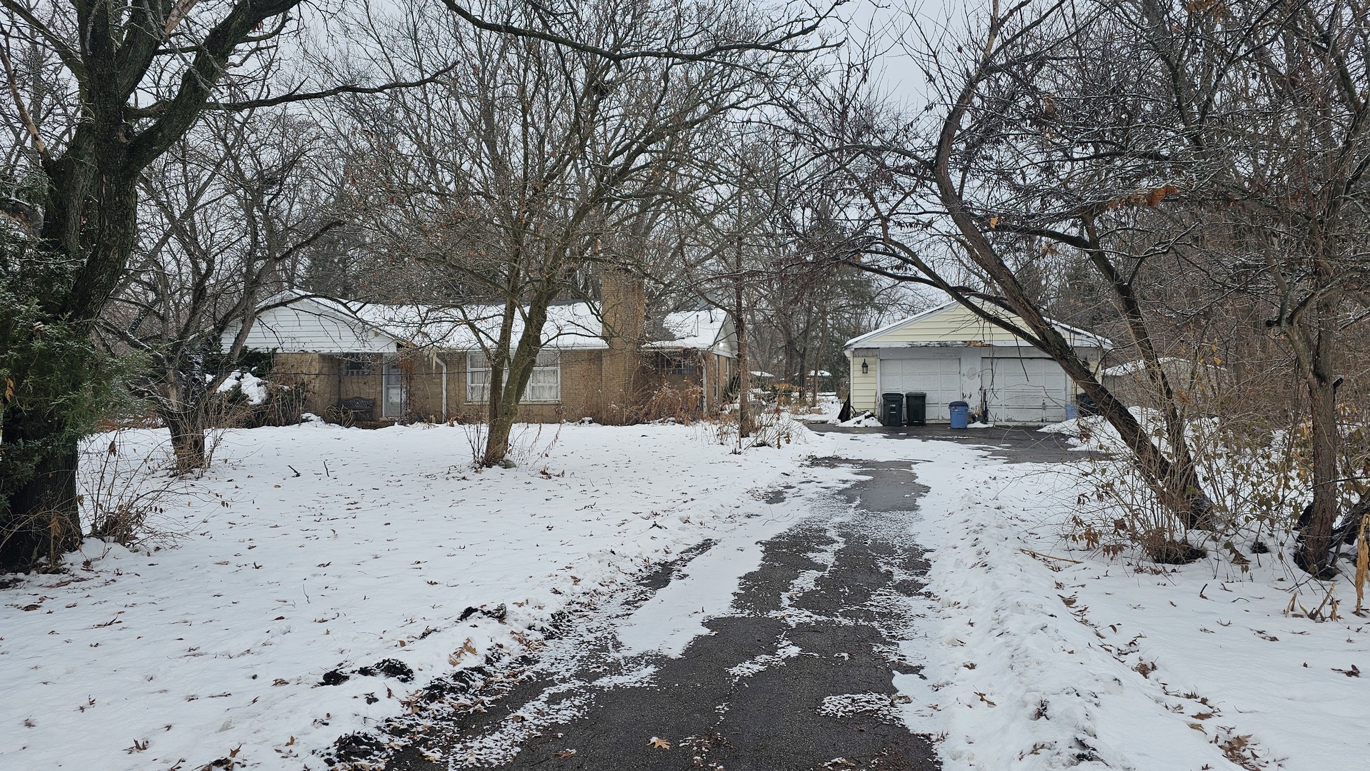 a view of a yard covered with snow in front of house