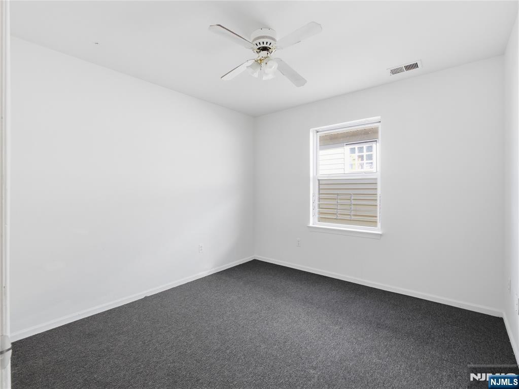 55 Lincoln Avenue, Unit 2 Newark, NJ 07104 - Photo 15 of 21 an empty room with a window and a ceiling fan