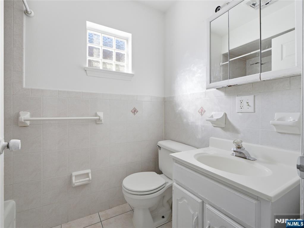 55 Lincoln Avenue, Unit 2 Newark, NJ 07104 - Photo 20 of 21 a bathroom with a sink a toilet and mirror
