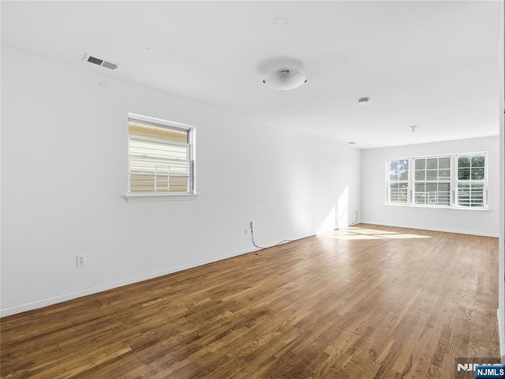 55 Lincoln Avenue, Unit 2 Newark, NJ 07104 - Photo 7 of 21 an empty room with wooden floor and windows