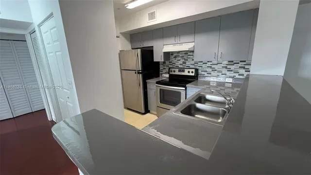 a kitchen with stainless steel appliances a refrigerator sink and microwave