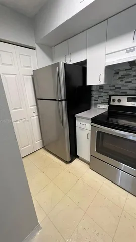 a kitchen with stainless steel appliances a refrigerator sink and cabinets