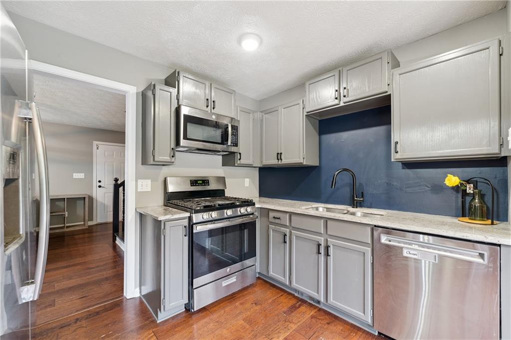 8020 Estee Drive Cumming, GA 30028 - Photo 11 of 41 a kitchen with stainless steel appliances granite countertop a stove a sink and a microwave