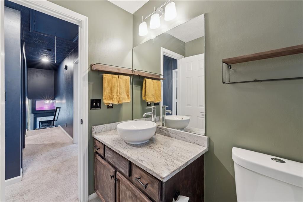 8020 Estee Drive Cumming, GA 30028 - Photo 15 of 41 a bathroom with a granite countertop sink a toilet and a mirror