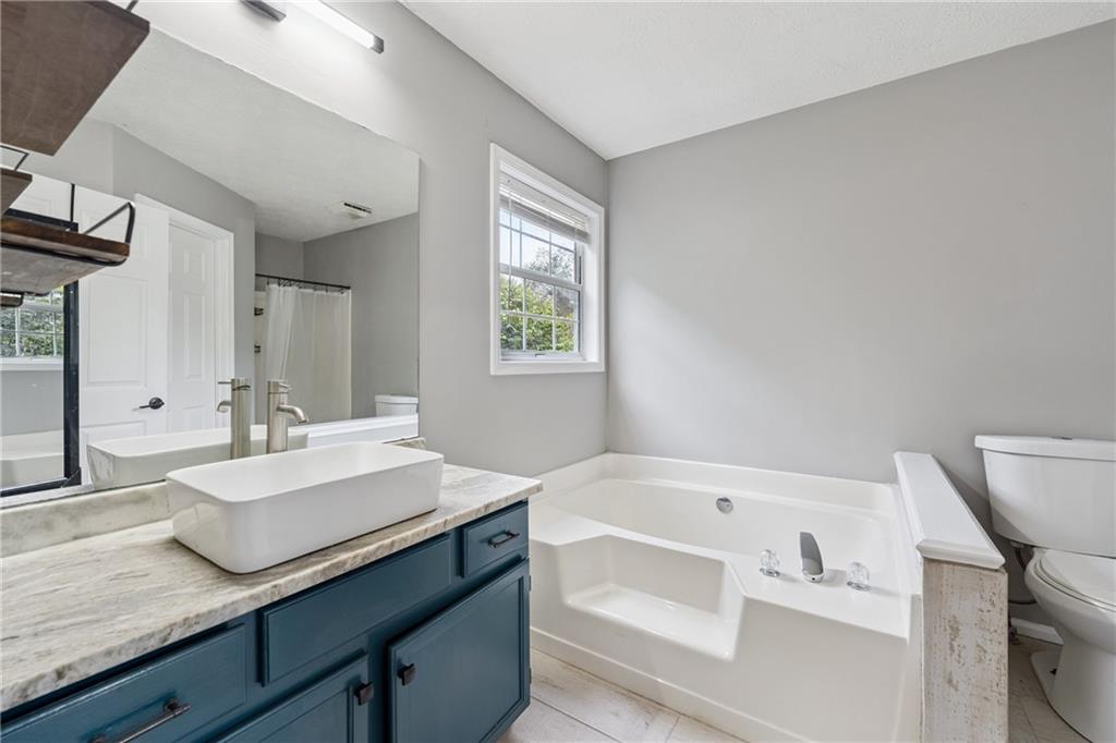8020 Estee Drive Cumming, GA 30028 - Photo 19 of 41 a bathroom with a bathtub sink and mirror