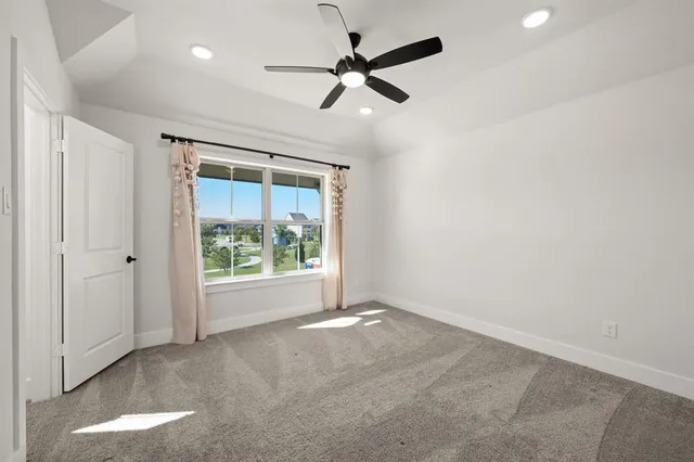an empty room with windows and a ceiling fan