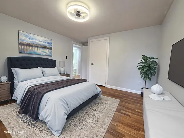 a bedroom with a bed and a potted plant