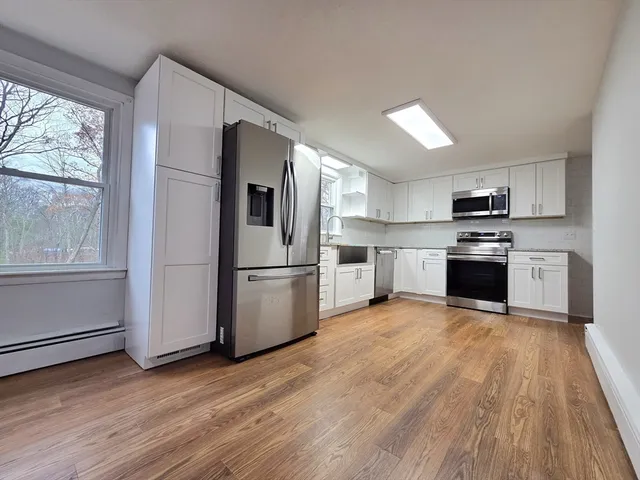 a kitchen with wooden floors and stainless steel appliances