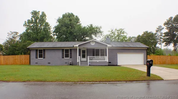 a front view of a house with a garden and trees