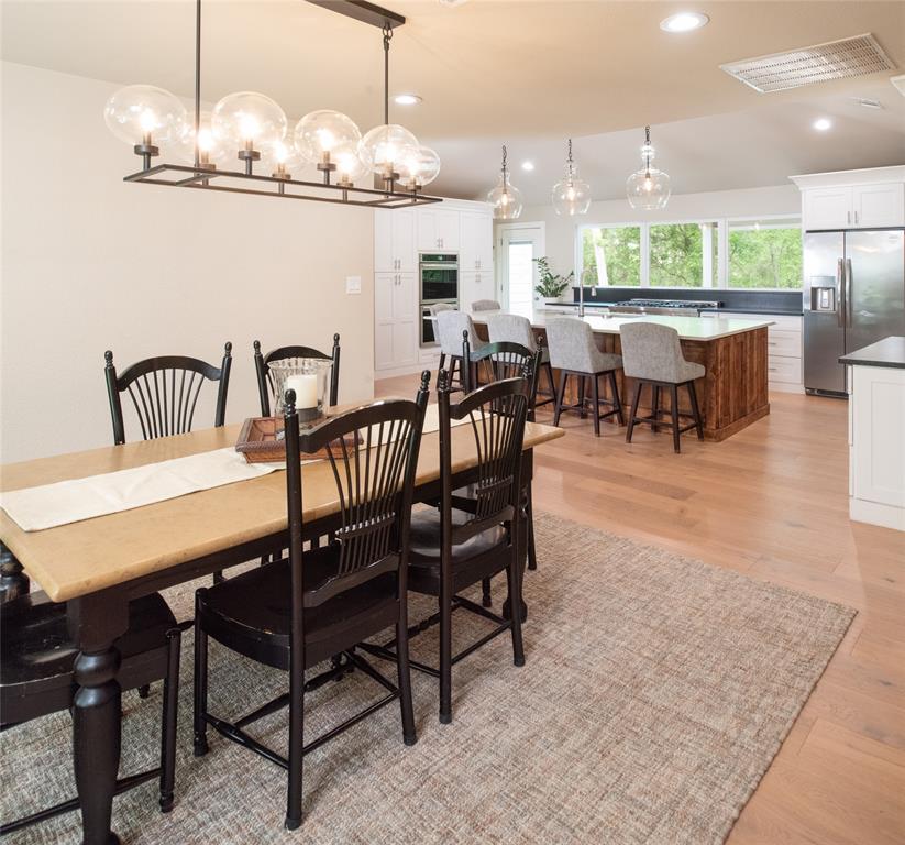 1451 Meandro Ria Lane Fairview, TX 75069 - Photo 7 of 38 a view of a dining room with furniture a chandelier and wooden floor