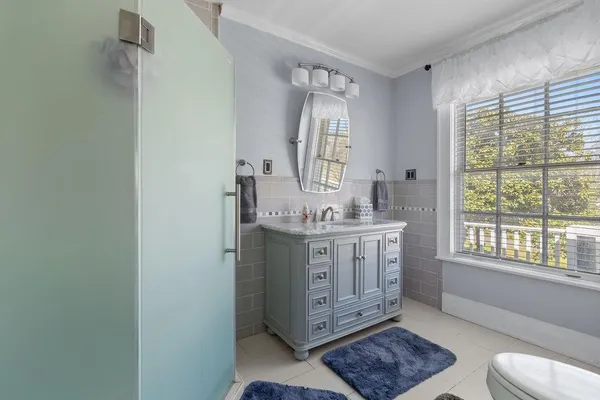 a bathroom with a granite countertop sink toilet and large mirror