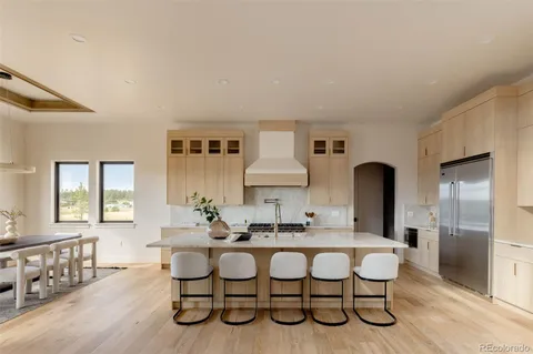 a living room with furniture a large window and wooden floor