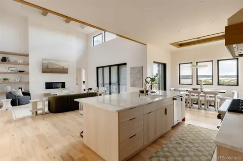 a large white kitchen with a large window and counter top space