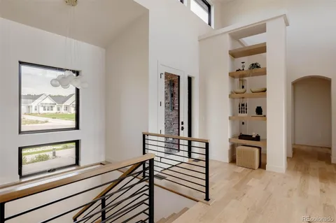 a view of a hallway with wooden floor and stairs