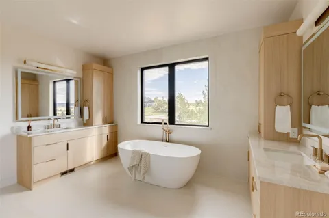a bathroom with a granite countertop sink and mirror with bathtub