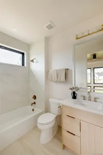 a bathroom with a toilet a sink a mirror and a bathtub
