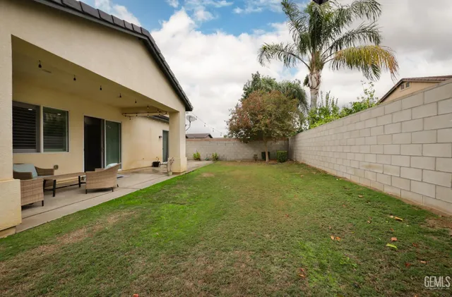 a backyard of a house with table and chairs