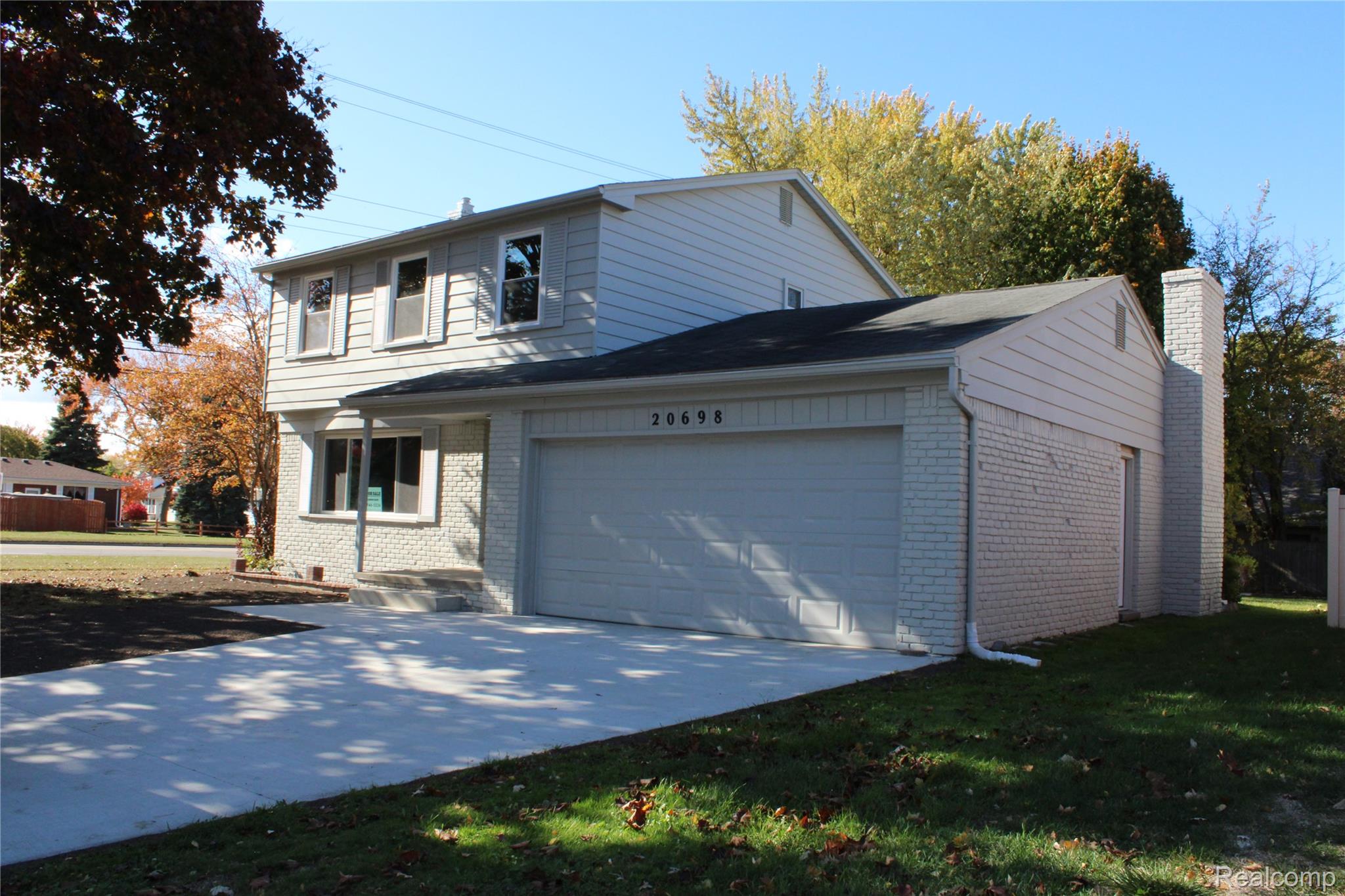 20698 Coachwood Road Riverview, MI 48193 - Photo 2 of 37 View of property exterior featuring brick siding, driveway, a garage, and a yard