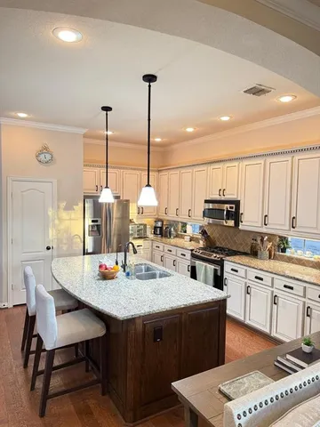 a kitchen with stainless steel appliances granite countertop a stove a sink dishwasher and a wooden cabinets