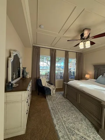 a bedroom with a bed a mirror on dresser and a chandelier