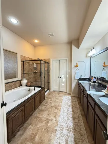 a large bathroom with a large tub sink shower and mirror