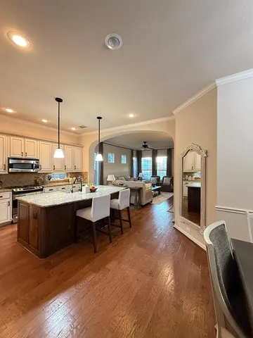 a open kitchen with stainless steel appliances granite countertop a stove and a refrigerator