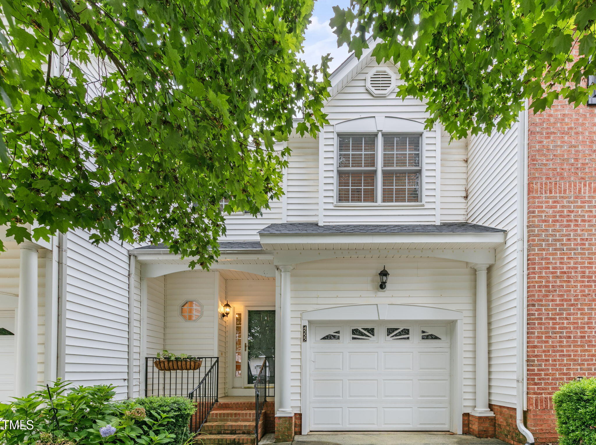 a front view of a house with a tree
