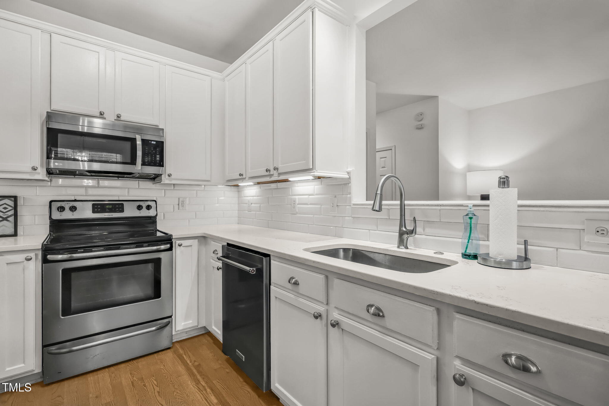 4555 Treerose Way Raleigh, NC 27606 - Photo 13 of 37 a kitchen with stainless steel appliances granite countertop a sink a stove a microwave and cabinets