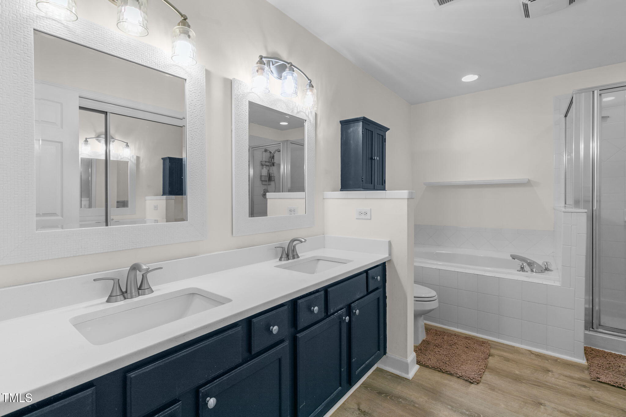 4555 Treerose Way Raleigh, NC 27606 - Photo 20 of 37 a bathroom with a tub sink double vanity and mirror