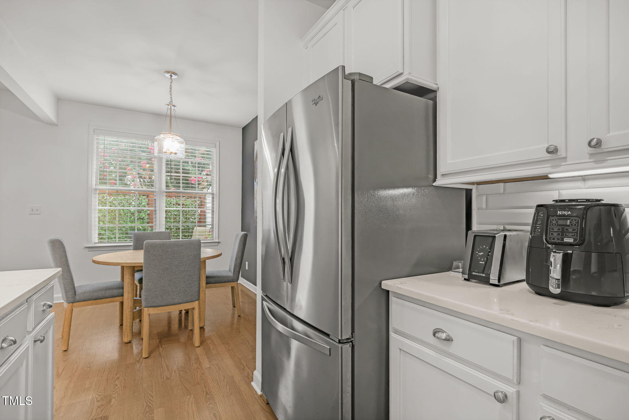 4555 Treerose Way Raleigh, NC 27606 - Photo 9 of 37 a kitchen with refrigerator a sink and chairs