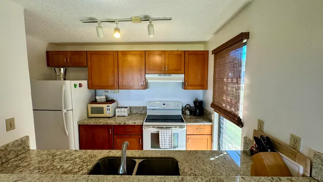 a kitchen with stainless steel appliances granite countertop a refrigerator and a stove