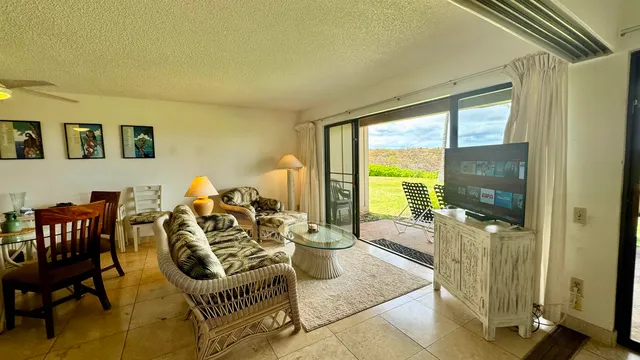 a bedroom with a bed and a potted plant on the dresser