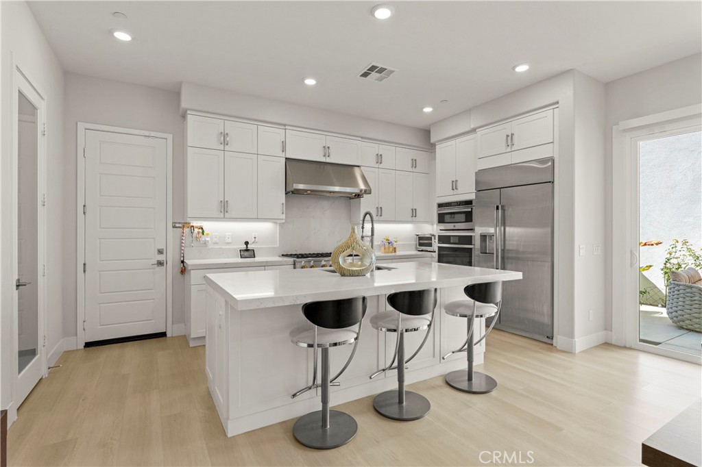 259 Chorus Irvine, CA 92618 - Photo 15 of 56 a kitchen with a sink a refrigerator and chairs