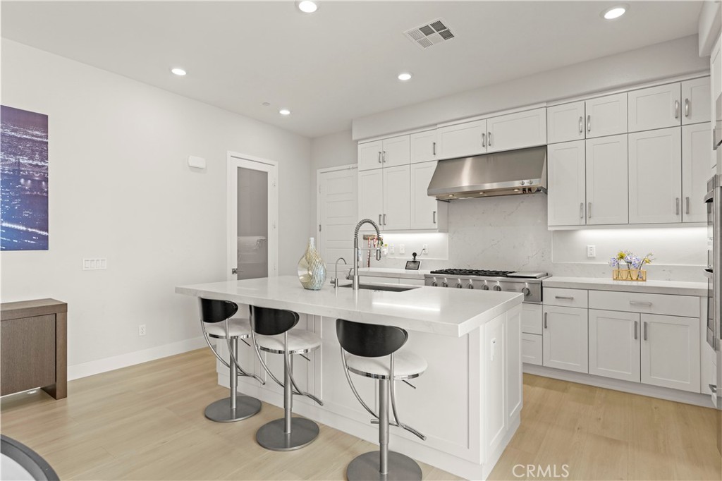 259 Chorus Irvine, CA 92618 - Photo 30 of 56 a kitchen with stainless steel appliances granite countertop a sink a stove a refrigerator and white cabinets with wooden floor