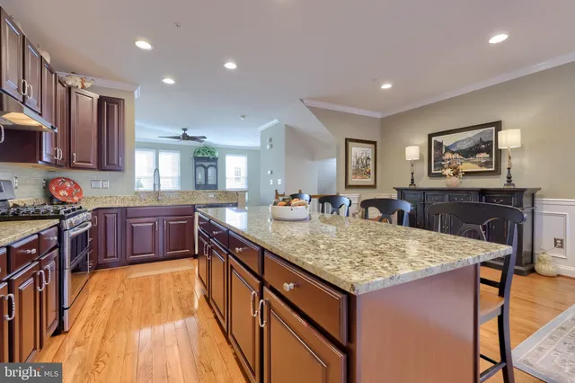 a kitchen with stainless steel appliances granite countertop sink stove and wooden cabinets